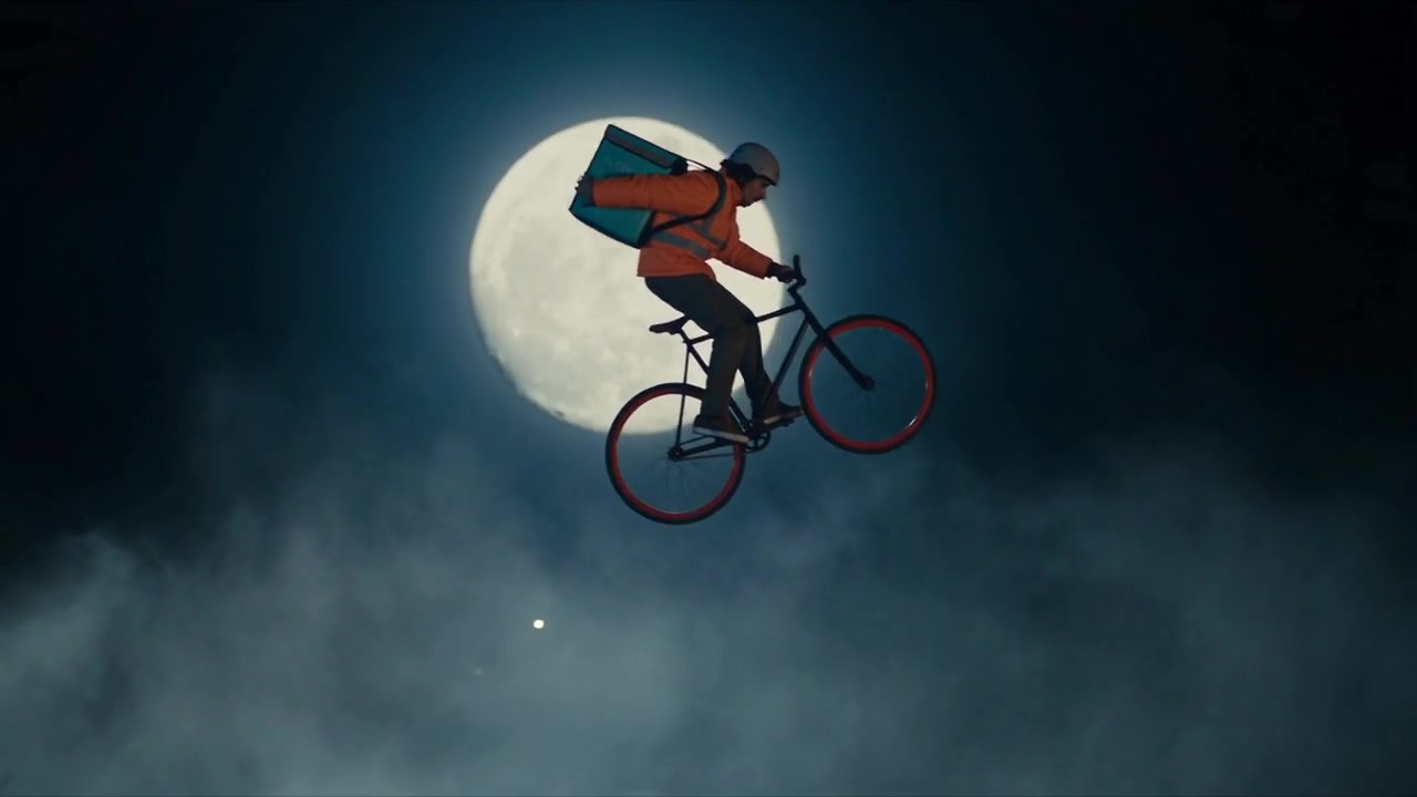 The courier jumps a canal against a full moon.