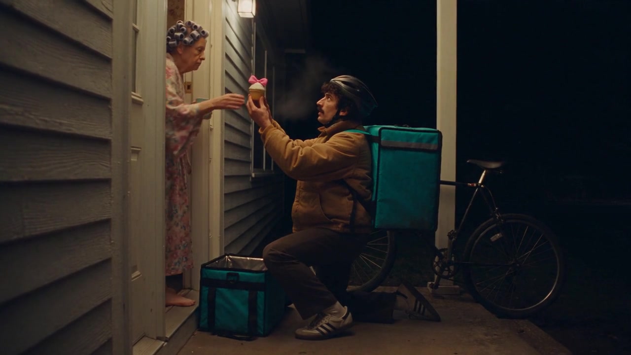 The same courier kneels at a door; the woman in the gown takes the cake.